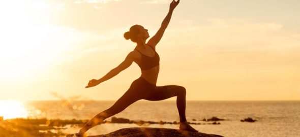 Kvinna yogar i solnedgången